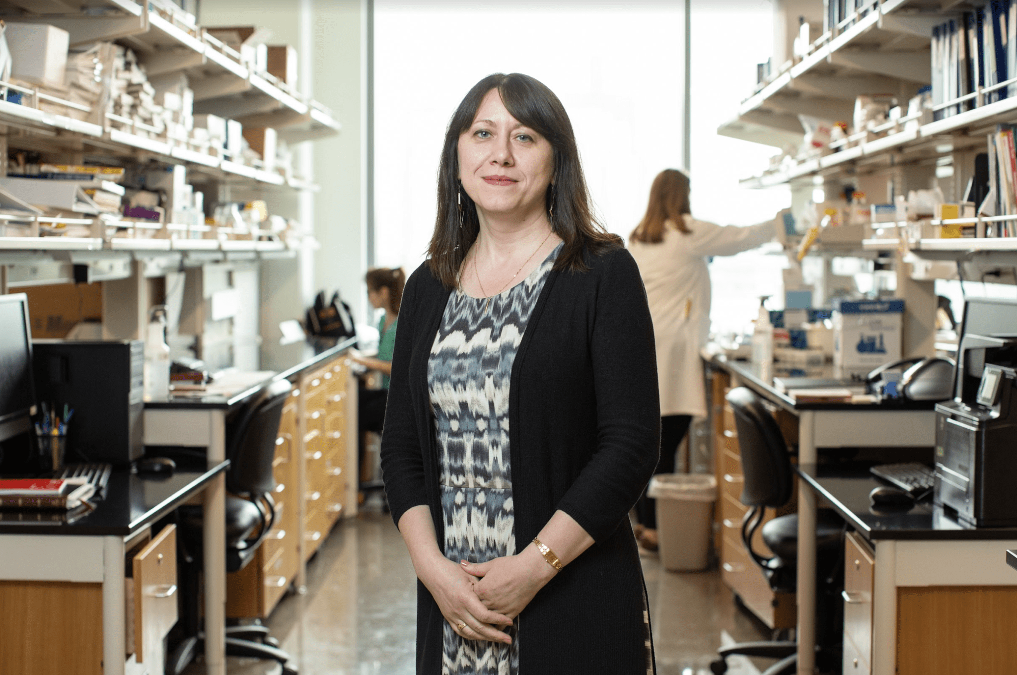 Irina Stepanov stands with her lab behind her on the UMN Twin Cities campus